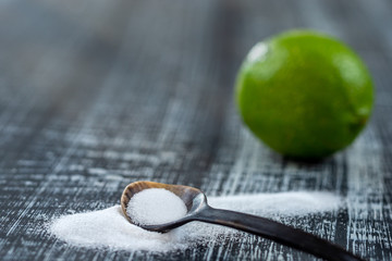 Baking soda - sodium bicarbonate and lemon. Natural, powder on a grey wooden background