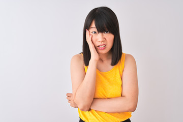 Young beautiful chinese woman wearing yellow t-shirt over isolated white background thinking...