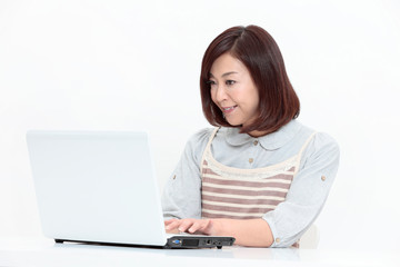 ノートパソコンを操作する中年女性