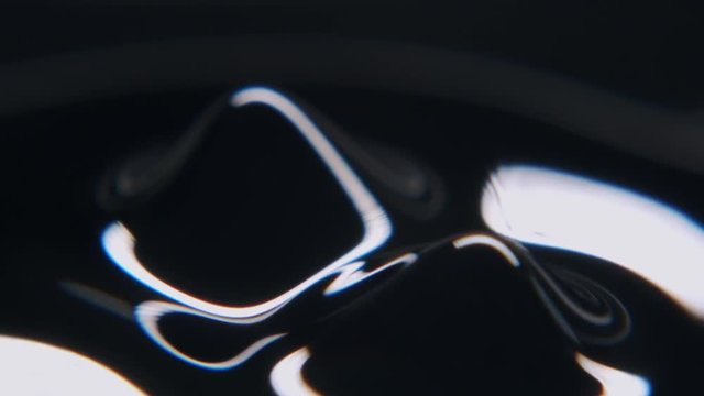 Black liquid forming abstract forms looking like spikes out of a flat surface.