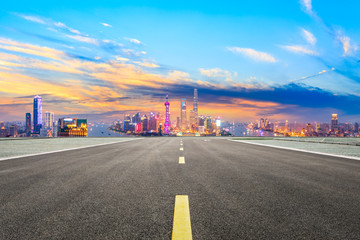 Empty asphalt highway and modern city skyline in Shanghai at sunset,China