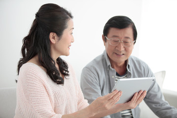 Obraz premium タブレットPCを見て話すシニア夫婦