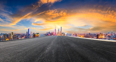 Empty asphalt highway and modern city skyline in Shanghai at sunset,China