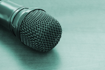 Microphone on wooden background with space for text