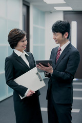 タブレットPCを持つビジネスマンとビジネスウーマン