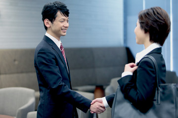 握手するビジネスマンとビジネスウーマン