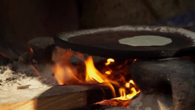Mexican woman from Cuetzalan making authentic tortillas by hand in a typical &ldquo;Comal&rdquo; pan.