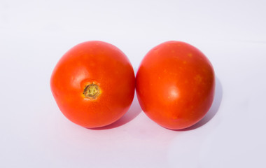 close up of two red tomatoes isolated on white background.