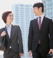 歩くビジネスマンとビジネスウーマン