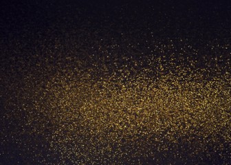 Fototapeta na wymiar Shimmer golden dust cloud abstract pattern on black background.