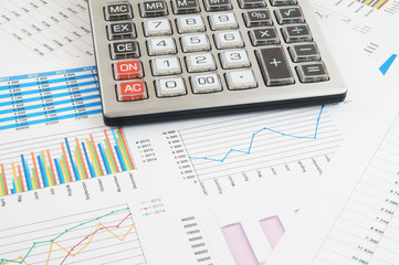 Business concept, calculator on financial charts and graphs