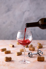 Red wine is poured into a glass. The concept of winemaking. Place under your text.