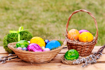 Colorful Easter eggs in wicker basket. Seasonal spring decoration.