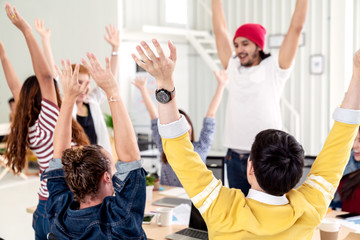 Naklejka na ściany i meble Young multiethnic diverse creative asian group huddle and high five hands together in office workshop with success or empower expression in teamwork. Young happy asian marketing team bonding concept.