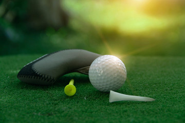 Golf ball and golf club in beautiful golf course at Thailand. Collection of golf equipment resting on green grass with green background
