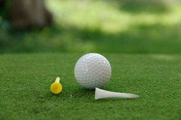 Golf ball and golf club in beautiful golf course at Thailand. Collection of golf equipment resting on green grass with green background