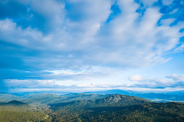Ultra wide panorama of skyline. Green mountains covered with forest on the blue sky background.  Amazing view on green mountains from a viewpoint