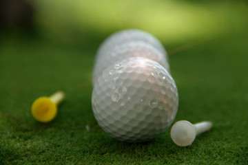 Golf ball and golf club in beautiful golf course at Thailand. Collection of golf equipment resting on green grass with green background