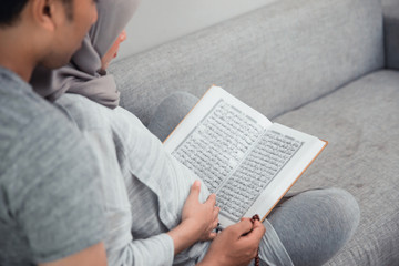 Fototapeta na wymiar wife and husband learn how to read qoran. muslim family reading holy book of islam
