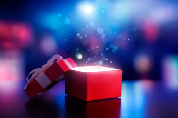 Red open gift box with magical light