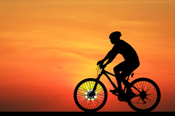 Fototapeta na wymiar Silhouette Cycling on blurry sunrise sky background.