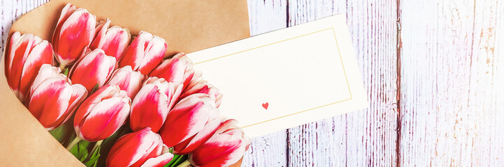 Bouquet of red tulips on the background of old, wooden boards. Place for text.
