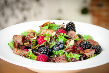 Salad bowl with grilled beef steak and berries