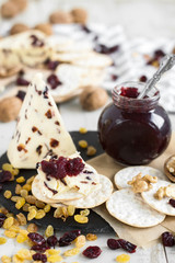 Crackers with cranberry cheese and jam served with raisin, walnut and dried cranberry