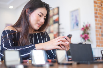 Happy girl blogger at cafe talking about makeup and beauty and recording video tutorial for...