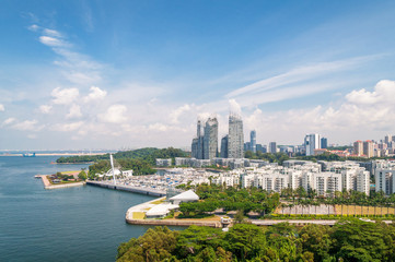 Aerial view of modern Asian cityscape with skyscrapers and tropical plants
