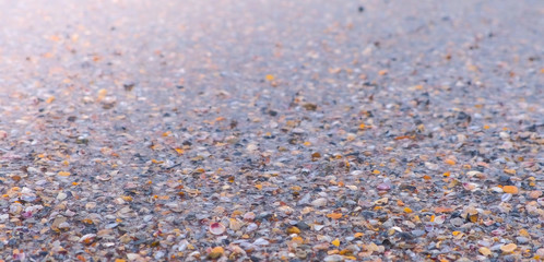 Sea waves on the sand beach with small shells, calm sea