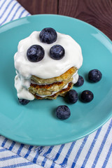 A stack of homemade pancakes with blueberries and sour cream. Cottage cheese pancakes