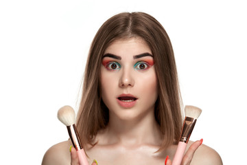 Closeup portrait of beautiful young woman with brushes for make-up