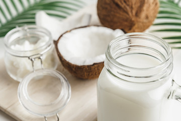 Organic healthy coconut butter and fresh coconut pieces on wooden board