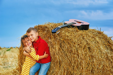 Cheerful children on a summer walk in the field . Beautiful brother and sister . Children in bright clothes