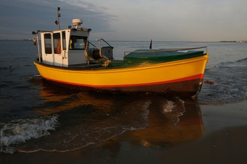 Fototapeta premium Wooden fishing boat on the beach of Baltic Sea in Sopot/Poland in sunny summer day. 