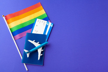 The concept of travel for gays and lesbians. Passport, toy plane and gay flag
