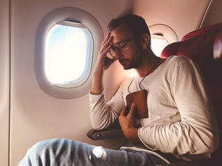 Airplane passenger with a neck bag for safe carrying money and documents.