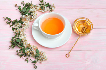 Green tea in a ceramic cup with branches of blossoming tree branches