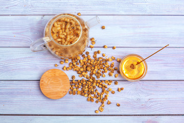 Healthy chamomile tea  in glass cup. Teapot, small honey jar