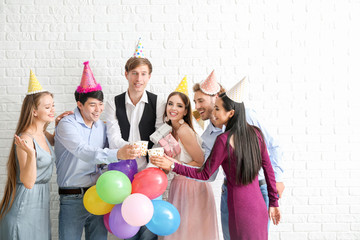 Group of friends celebrating Birthday on near brick wall