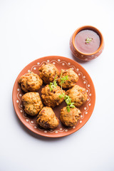 rava Bhajj or bhajiya also known as suji Pakoda or semolina Pakora, served with tomato ketchup. selective focus
