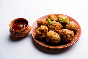 rava Bhajj or bhajiya also known as suji Pakoda or semolina Pakora, served with tomato ketchup. selective focus