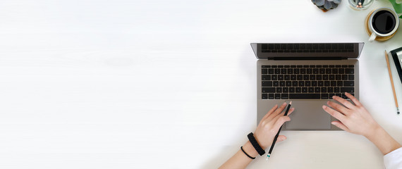 Female writer typing using laptop keyboard and wood copy space