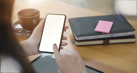 Female hand holding and using mobile smartphone