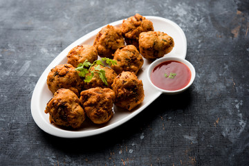 rava Bhajj or bhajiya also known as suji Pakoda or semolina Pakora, served with tomato ketchup. selective focus