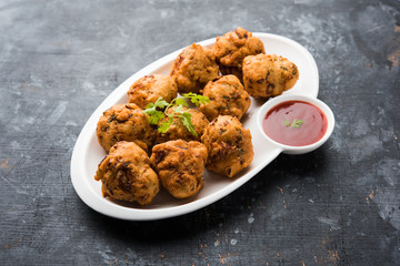 rava Bhajj or bhajiya also known as suji Pakoda or semolina Pakora, served with tomato ketchup. selective focus