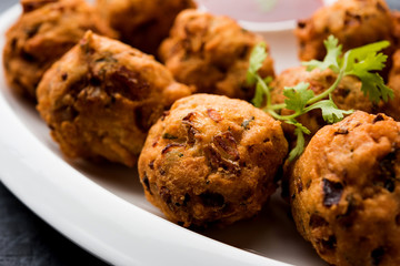 rava Bhajj or bhajiya also known as suji Pakoda or semolina Pakora, served with tomato ketchup. selective focus