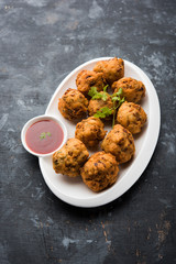 rava Bhajj or bhajiya also known as suji Pakoda or semolina Pakora, served with tomato ketchup. selective focus