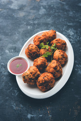 rava Bhajj or bhajiya also known as suji Pakoda or semolina Pakora, served with tomato ketchup. selective focus